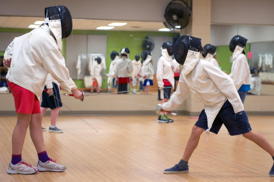 Kids practice their fencing techniques with each other.