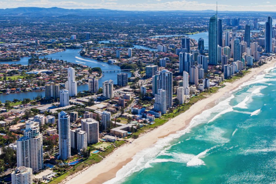 Arial view of skyscrapers lining a long, sandy beachfront.