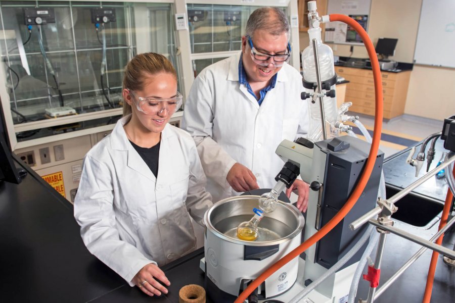 Student and former scholarship recipient Harley Bray works in a lab with an instructor.