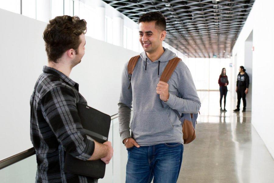 Two students talking in a hallway