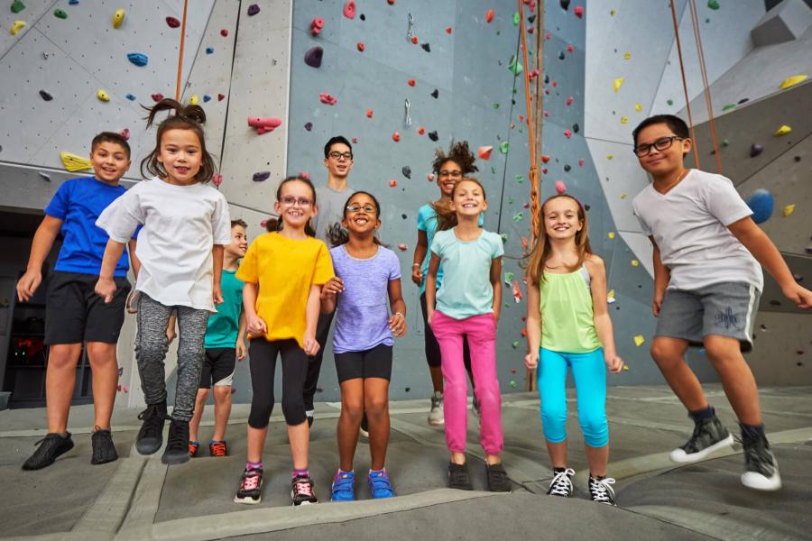 a group of kids jumping in unison in front of the wall