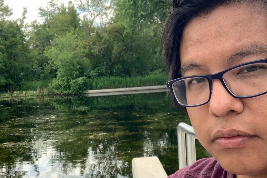 PIA, Tyler, standing in front of a pond.