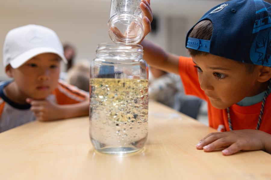 children pouring oil substance into water