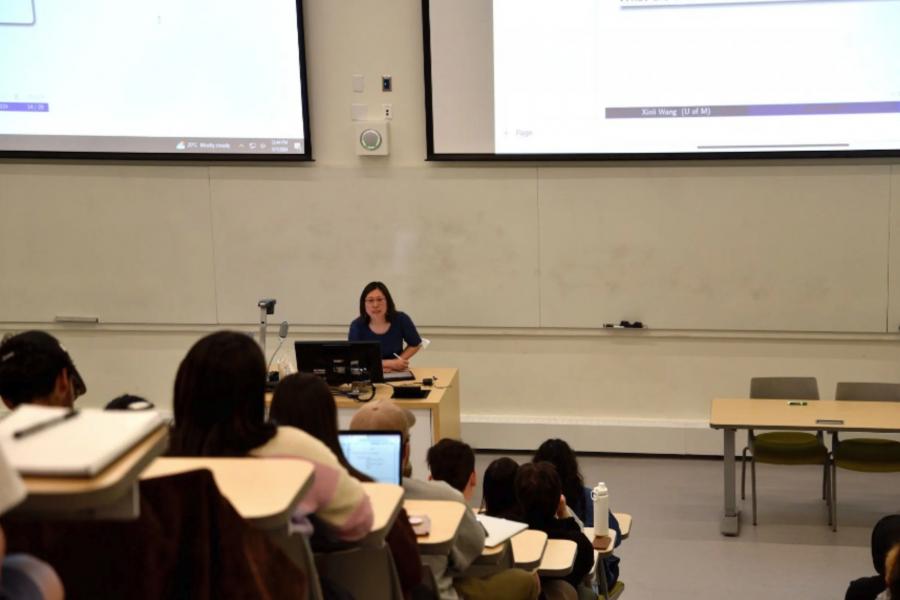 Xinli Wang giving a lecture to a students. 