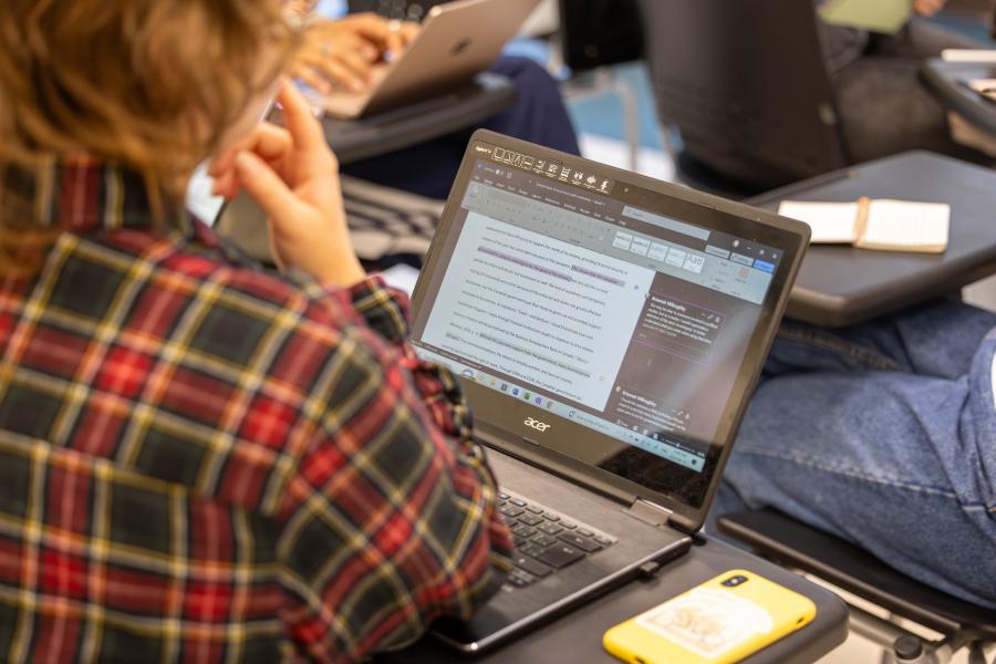 An over the shoulder look at a student's laptop screen that shows an open word processor