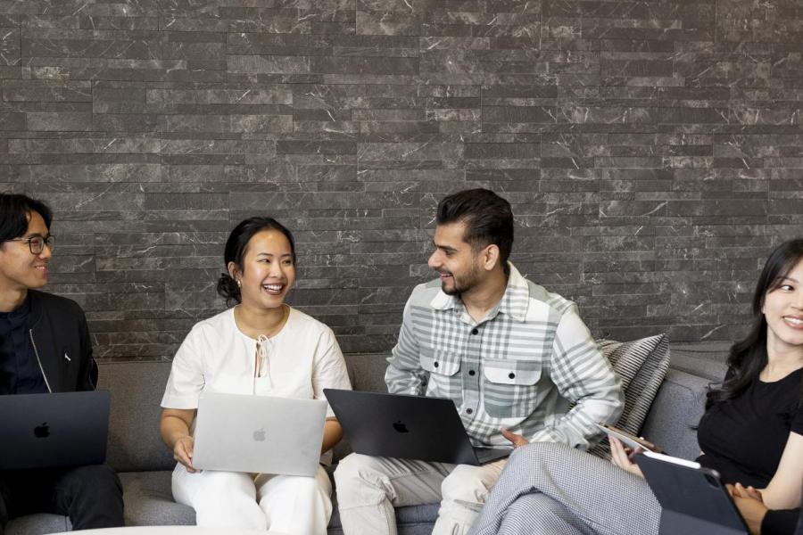 students sitting with their laptops in a discussion