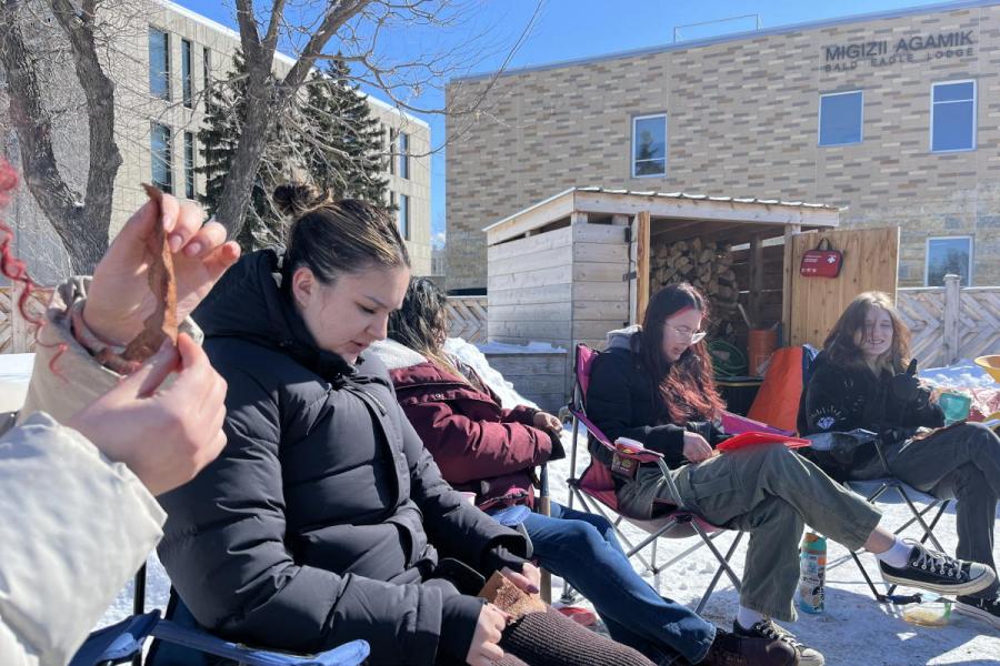 Group of people making fish skin leather at the UM Sweat Lodge site.