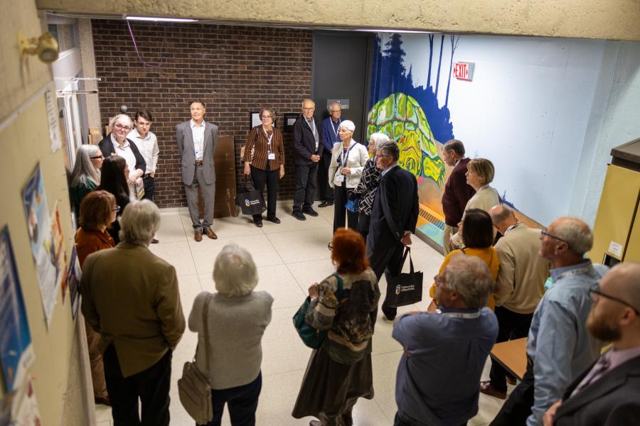 Members of the Law Class of 1976 during Robson Hall Tour in front of the Turtle Island mural