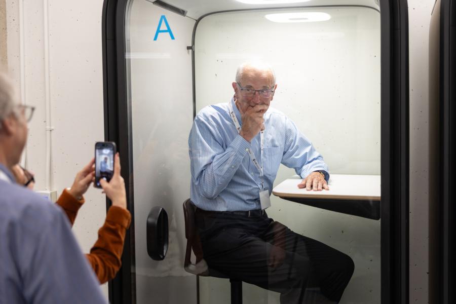 Member of the Law Class of 1976 testingthe sound proof booth in the L. Kerry Vickar Business Law Clinic