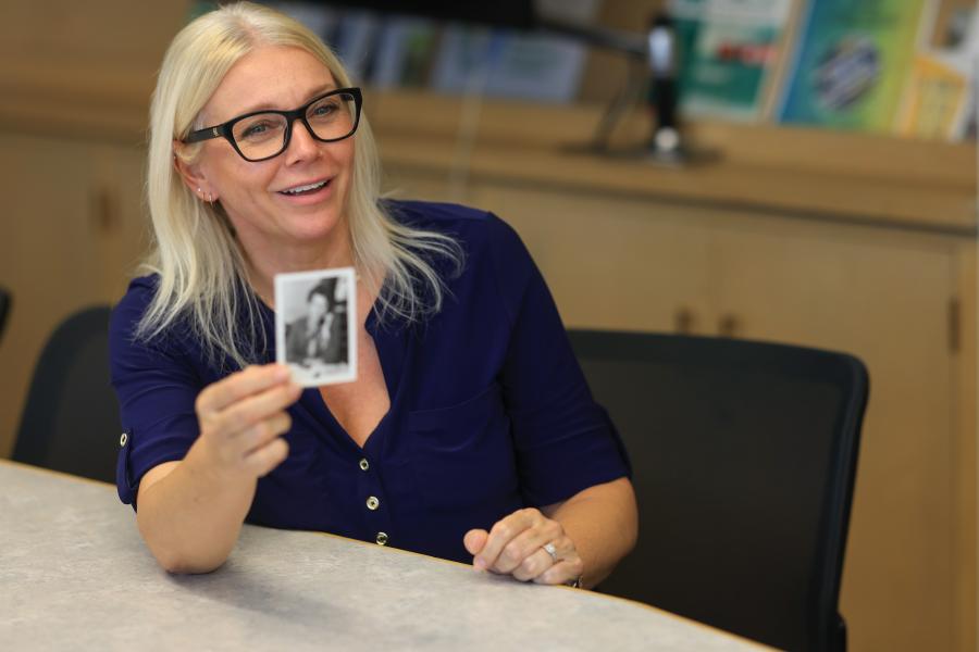 NRI Staff member holding nostalgic photo