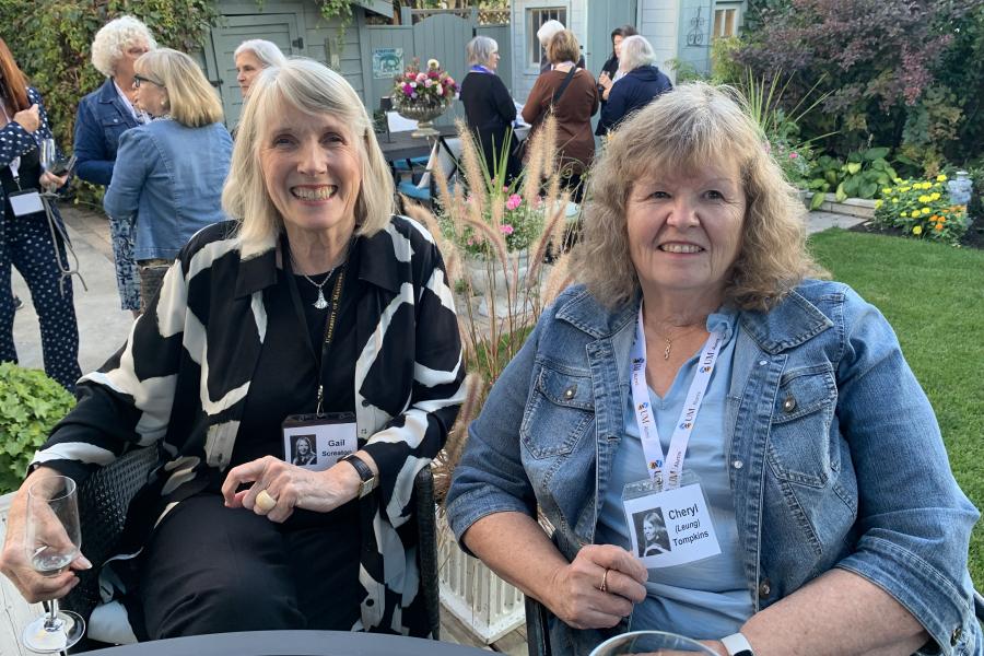 two classmates visiting in backyard at welcome reception