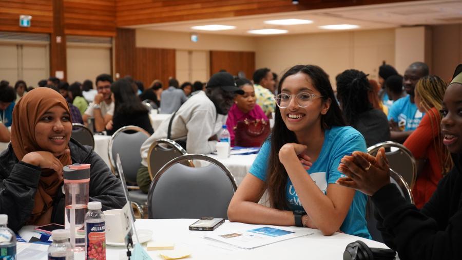 Volunteer smiles at a table with new students