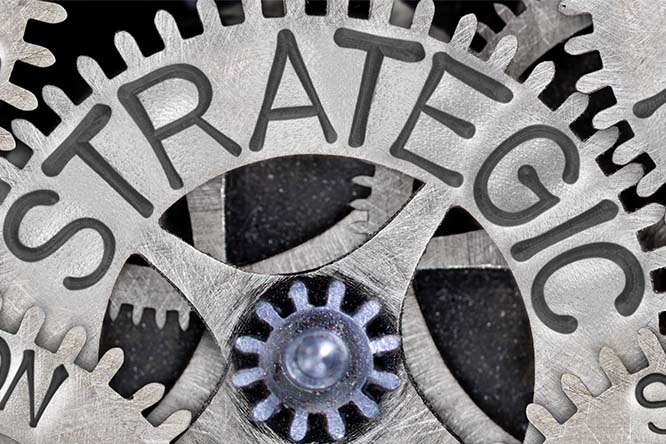 A close-up of a cogwheel with the words strategy on it