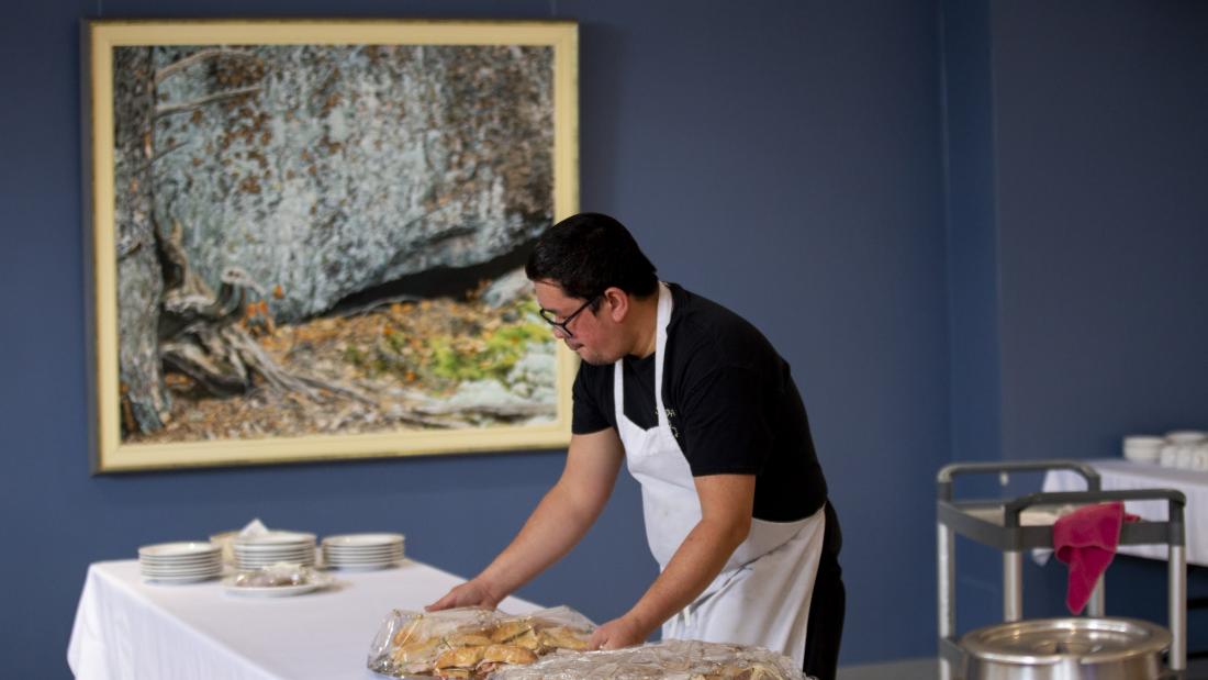 Man in an apron serving food platters