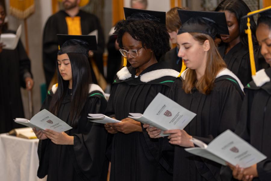 Graduates reading from a booklet