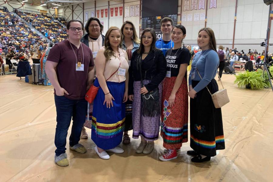 A group of eight indigenous student stand together for a photo during the graduation Pow-Wow.